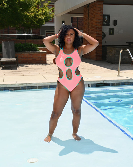 Woman in a pink swimsuit standing by a pool